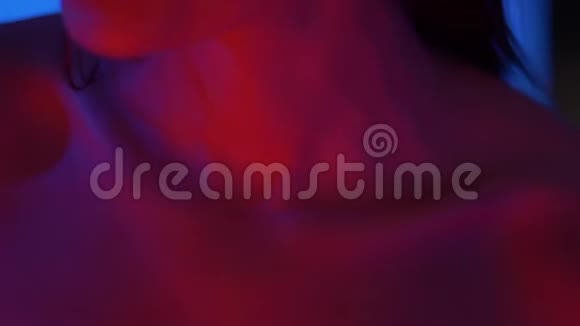 特写镜头的锁骨和嘴唇的未来时尚模特在明亮的红色霓虹灯在工作室视频的预览图