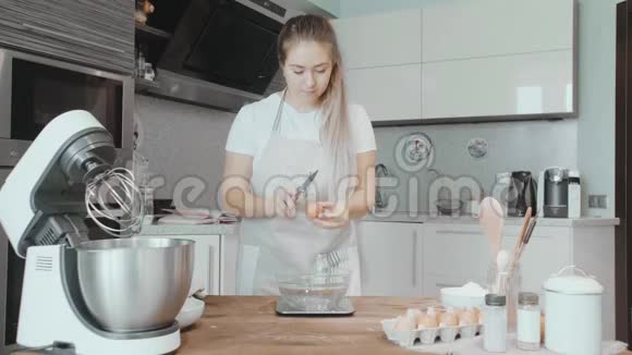 库克女人正在打破鸡蛋蛋糕烹饪视频的预览图