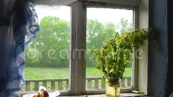从旧农舍的窗户上看到夏天的风景下着雨视频的预览图