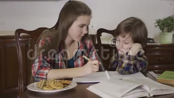 可爱的姐姐和可流产的弟弟学习的画像一个女孩和一个小男孩做家庭作业视频的预览图