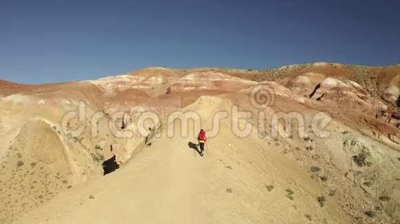 一位女游客登上山顶的航拍镜头带着红色背包的女人视频的预览图
