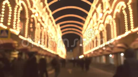 美丽的建筑在晚上的圣诞灯里有拱门城里的人在街上散步布鲁尔视频的预览图