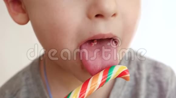 嘴的一个小孩子特写快乐的男孩喜欢吃甜糖果巧克力丘帕杯糖果和视频的预览图