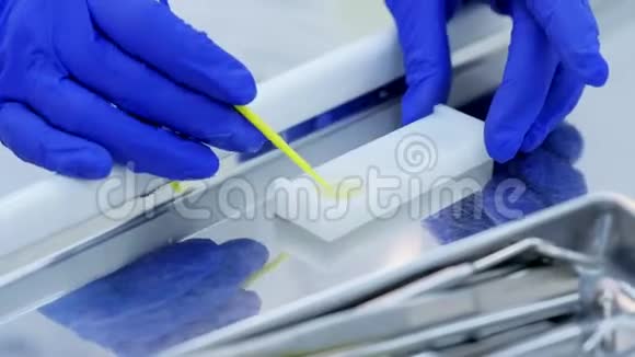 牙医为牙齿手部特写的荧光程序准备氟化物视频的预览图
