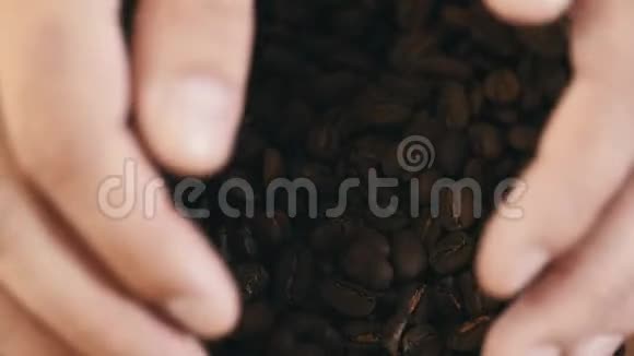人从盘子里拿起一把咖啡豆特写全是美味的4K阿拉伯视频的预览图