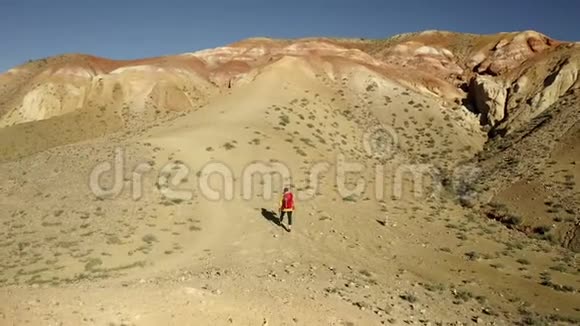 一位女游客登上山顶的航拍镜头带着红色背包的女人视频的预览图