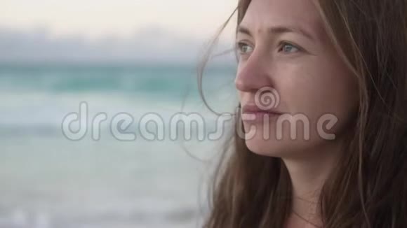 海背景下一位美丽的年轻女子的特写视频的预览图