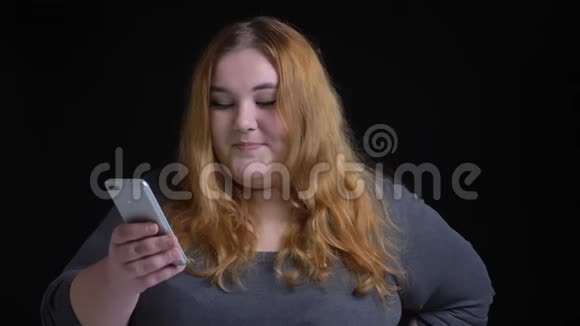 年轻的超重白种人女性在手机上浏览并在社交媒体上做出反应的特写镜头视频的预览图