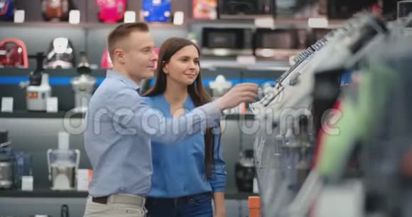在电器商店里一对幸福的夫妻一男一女穿着休闲服选择一个搅拌机购物由视频的预览图