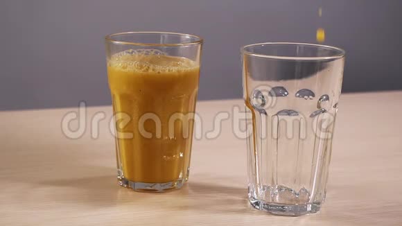 一杯空杯子装满新鲜橙汁慢动作白色背景特写视频的预览图