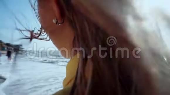 一个女孩的脖子特写她的头发里有风在远处看着什么东西女人的身体部分在海滩焦点视频的预览图