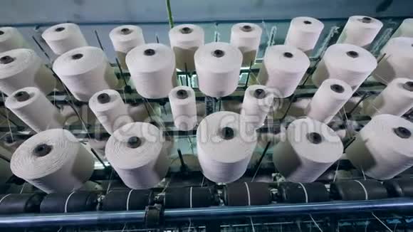 纺织厂设备上用白色纤维旋转筒管纺织厂设备在工作视频的预览图
