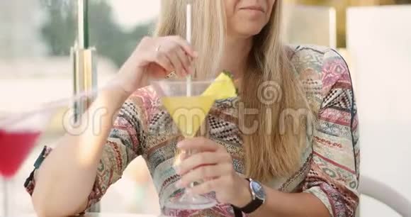 成年妇女在度假时喝含菠萝的酒精鸡尾酒视频的预览图