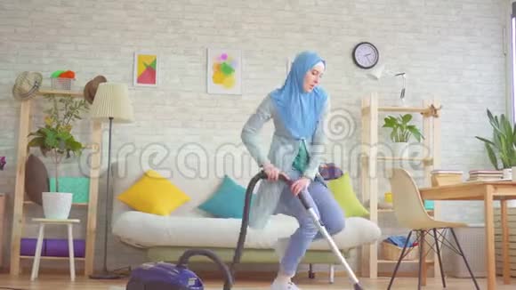 穆斯林妇女戴头巾抽真空地毯跳舞唱歌视频的预览图