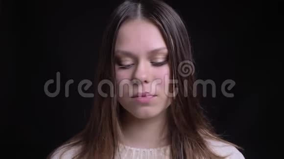 一位年轻漂亮的白种人女性在镜头前梳着深色头发开心地笑着的特写镜头视频的预览图