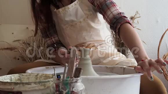 波特女人用陶工轮子雕刻粘土制品视频的预览图