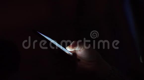 夜间办公室人手中智能手机的特写视频的预览图