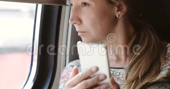 一个女人在火车上用手机的肖像视频的预览图