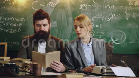 长胡子的教授和他的女助手在桌上工作背景是板上的数学公式青年视频的预览图