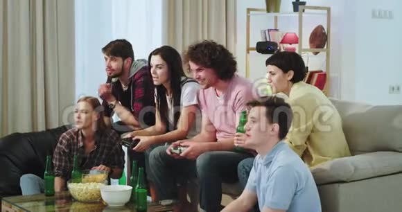 在一个客厅里一大群多民族的朋友在电视前玩电子游戏视频的预览图