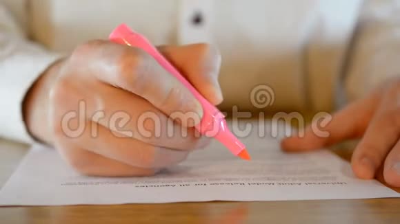 男性手的特写用记号笔在商务文件中标记重要文字视频的预览图