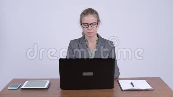 年轻糊涂的金发女商人在工作中使用笔记本电脑和耸肩视频的预览图