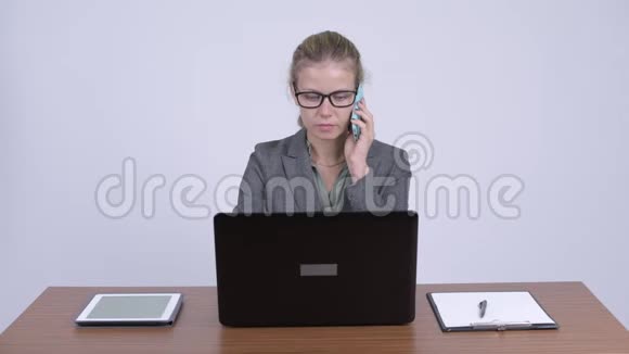 年轻愤怒的金发女商人在工作时打电话视频的预览图