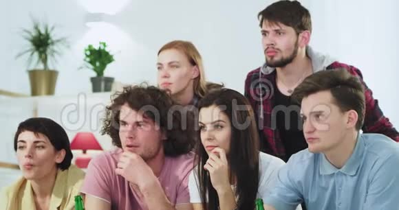 在镜头前一大群吸引人的朋友集中观看电影或体育比赛制作一个视频的预览图