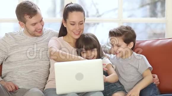 家里有两个小孩坐在沙发上用笔记本电脑视频的预览图