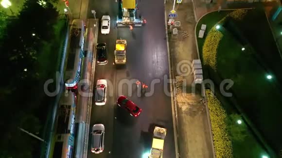 在市中心夜间铺设沥青电车和汽车经过从无人机俯视视频的预览图