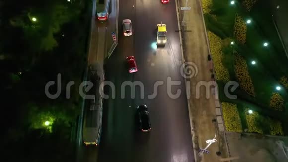 空中拍摄的人们在夜间工作在城市里铺设沥青路边的汽车交通无人机的4K录像视频的预览图