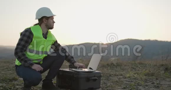 戴着安全夹克的安全帽的工业工程师使用触摸屏笔记本电脑他在重工业工作视频的预览图