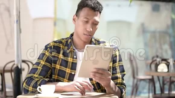 非洲年轻人对平板电脑故障的反应户外咖啡馆视频的预览图