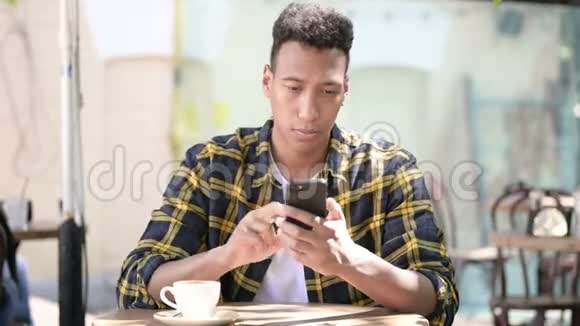 非洲年轻人庆祝智能手机户外咖啡馆的成功视频的预览图