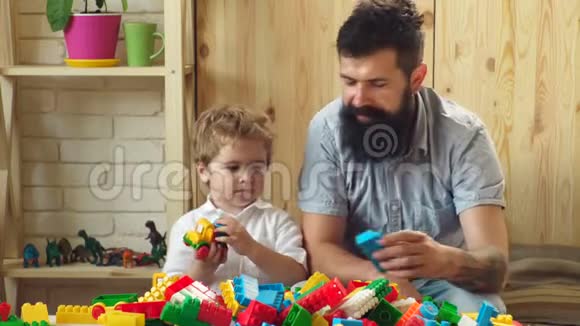 良好的育儿观念小男孩和爸爸一起玩父子俩玩游戏家庭休闲快乐爱的儿子视频的预览图