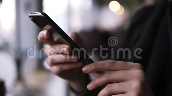 将女性的手拿着智能手机手指放在触摸屏上女人用手机上网视频的预览图