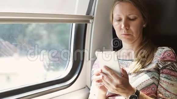 漂亮的成年女人坐火车在手机上看书视频的预览图