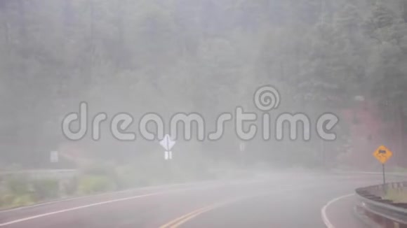 在潮湿的雨天沿着弯曲的山路行驶视频的预览图
