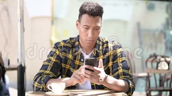 年轻的非洲男人为失去智能手机而烦恼户外咖啡馆视频的预览图