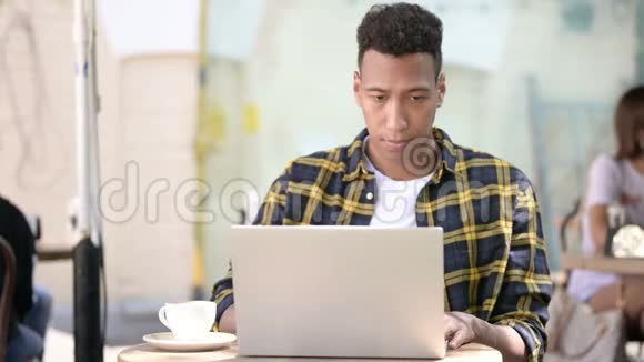 非洲年轻人的笔记本电脑在线视频聊天户外咖啡馆视频的预览图