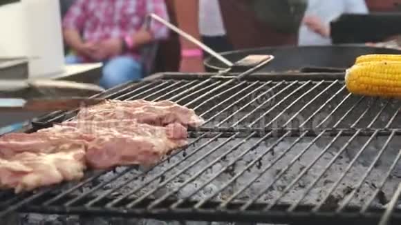 厨师把肉和蘑菇放在烤架上街头美食节视频的预览图