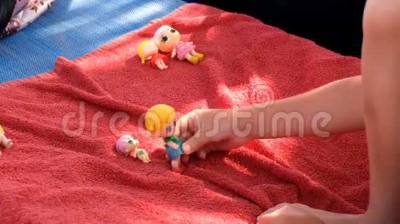 在阳光明媚的一天可爱的女孩在沙滩上的日光浴床上玩她的娃娃视频的预览图