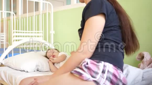 孩子生病了妈妈怜悯孩子带着体温计躺在床上的生病的孩子母亲旁边有一个生病的女儿孩子有一个视频的预览图