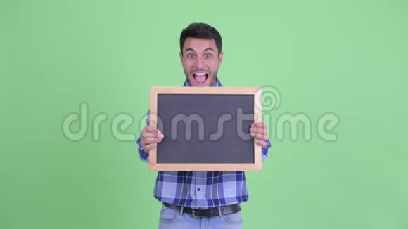 快乐的西班牙年轻人拿着黑板看上去很惊讶视频的预览图