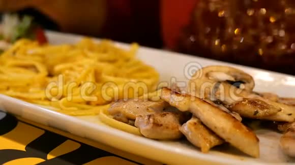 酱面和炒肉的意大利面是用白色盘子里的金属叉子吃的有选择的焦点视频的预览图