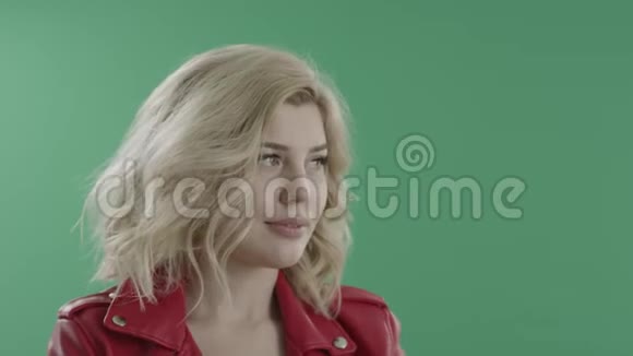 穿着红色夹克和绿色屏幕的迷人害羞女人视频的预览图