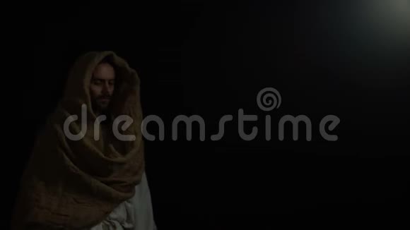 穿着长袍的人从黑暗中走出来看着镜头圣经弥赛亚上帝视频的预览图