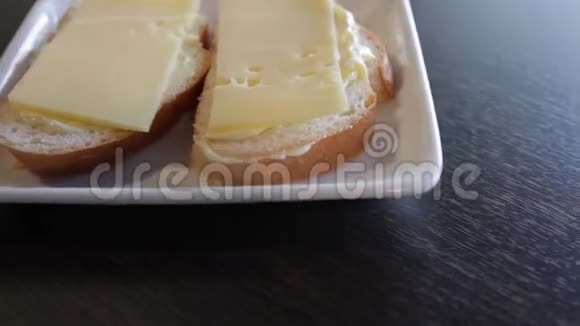 两个白色面包三明治盘子里有黄油和奶酪摄像机绕着这个向左移动特写视频的预览图