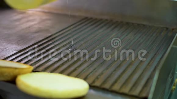 厨师用手将油浇在大烤架上然后在上面放上馅饼视频的预览图