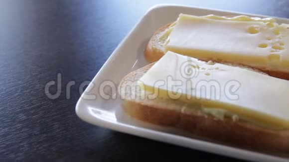 两个白色面包三明治盘子里有黄油和奶酪摄像机绕着这个向右移动特写视频的预览图